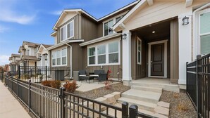 A row of townhouses with a covered front porch, a black metal fence, and a gravel pathway. - Near Eagle Island | Pool | 2 King Beds | Parking | Smart TV (Eagle)