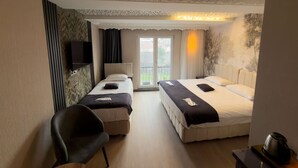 A hotel room with two beds, a chair, a TV, and a balcony with a view. - steelbutikotel (Kocasinan)