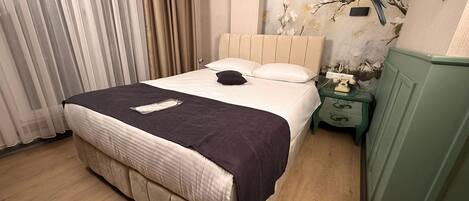 Un dormitorio con cama, mesita de noche, teléfono y un mural en la pared.