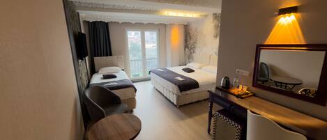 Une chambre d’hôtel comprenant un lit, un bureau avec une chaise, une petite table et un miroir.