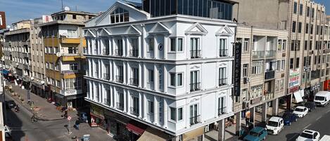 Un hotel de varios pisos con un estilo arquitectónico clásico, con balcones y ventanas amplias.