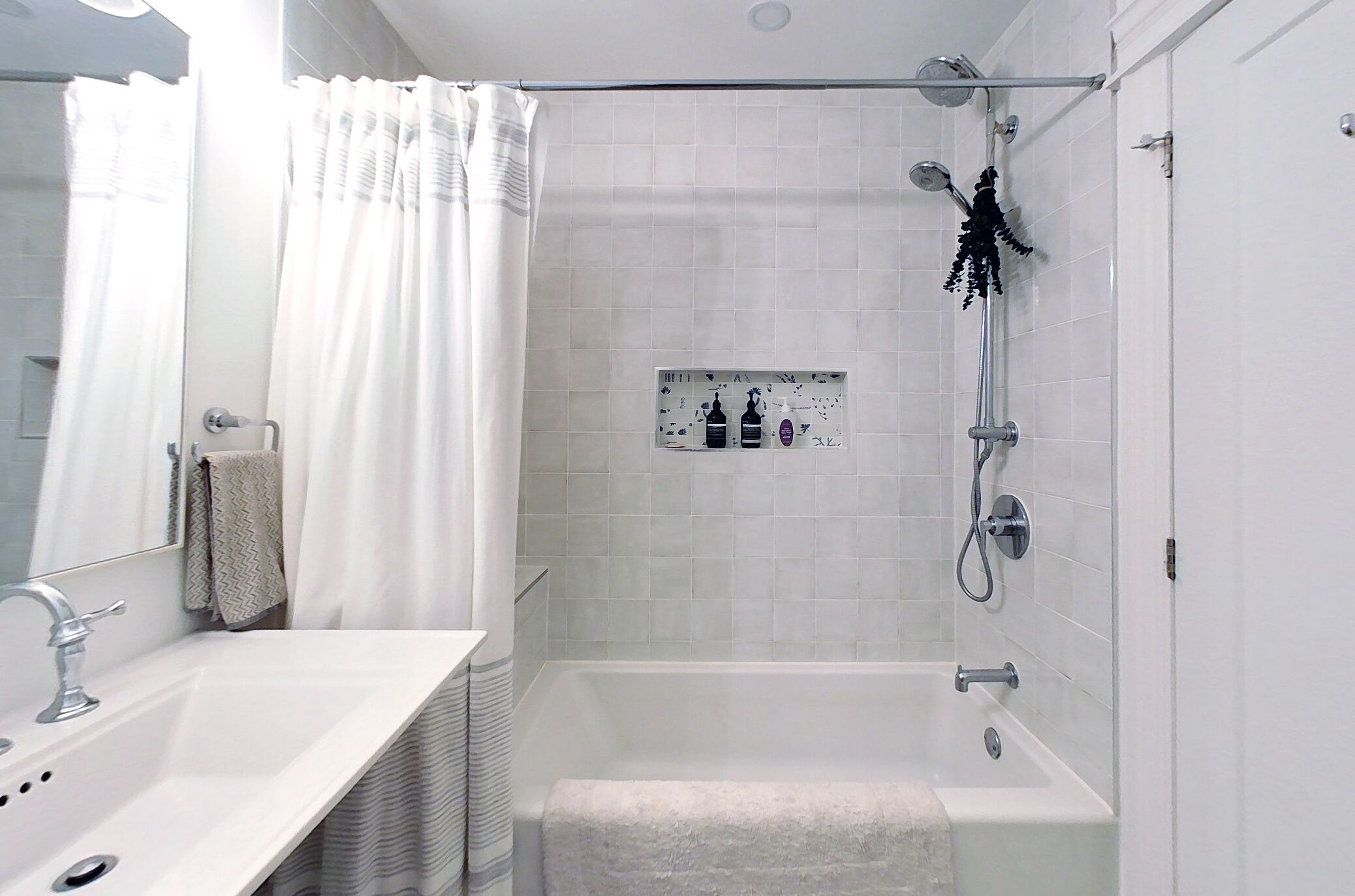 Un baño moderno con bañera, ducha y tocador con lavamanos.