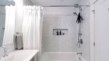 Un baño moderno con bañera, ducha y tocador con lavamanos.