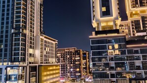 Un edificio moderno de gran altura con varios pisos, ventanas amplias y una fachada bien iluminada durante la noche.