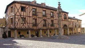 Un bâtiment traditionnel à colombages, doté d’une cour et d’une fontaine.