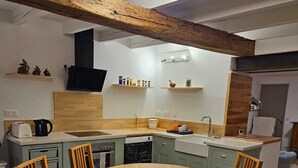 Une cuisine moderne avec un îlot central, des chaises en bois et une table à manger ronde.