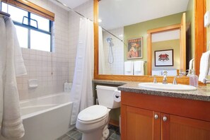 A bathroom with a bathtub, toilet, and sink. - Charming 4BR/5BA on Golf Course w/ Private Garage (Whistler)