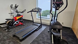 A gym with a treadmill, elliptical, and stationary bike. - Foxes in Downtown (Québec)