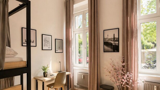 A room with a bunk bed, a desk with a chair, a radiator, and a window with curtains. - Berlin Sleep Club (Berlin)