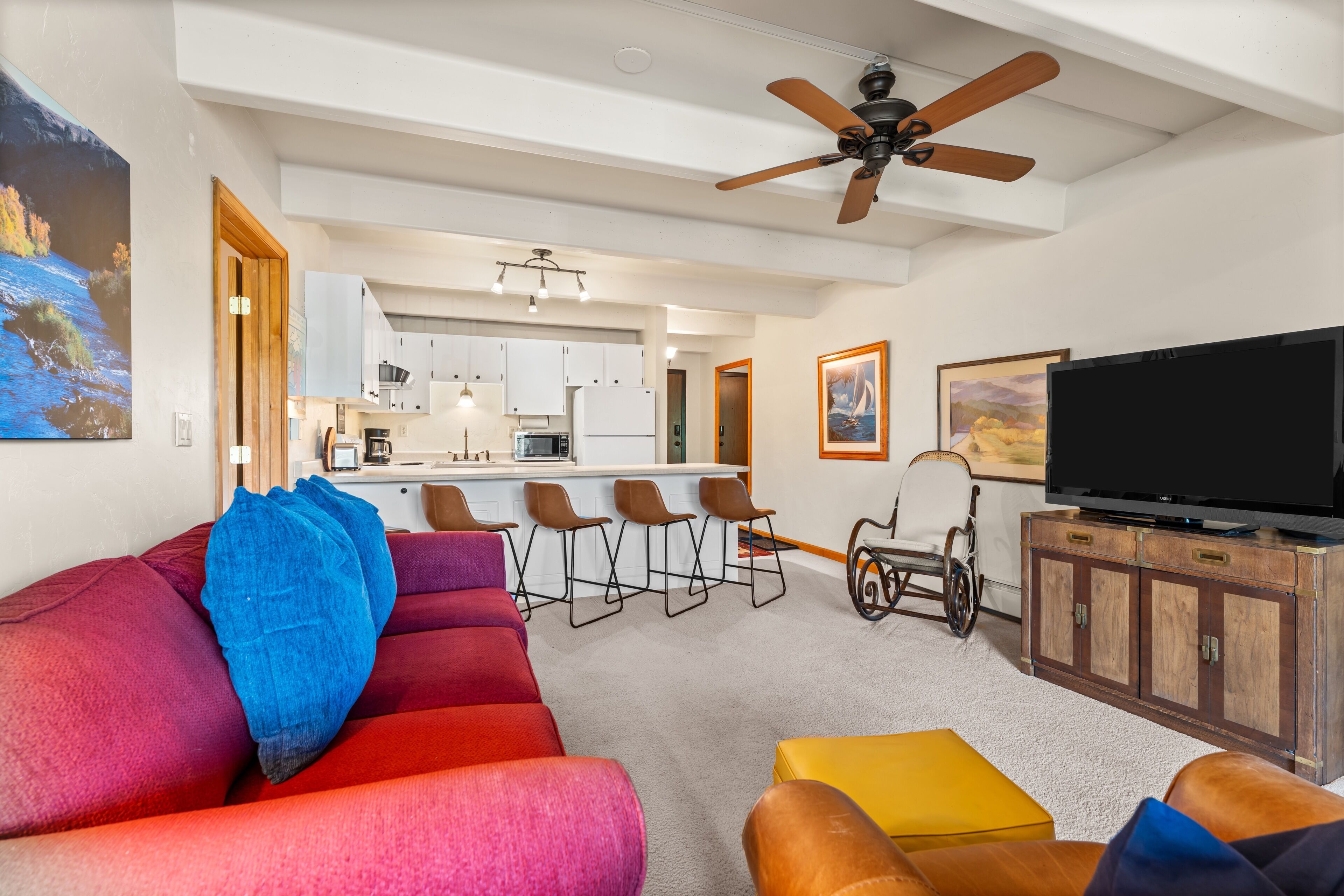 A modern living room with a sofa, a television, and a wheelchair.
