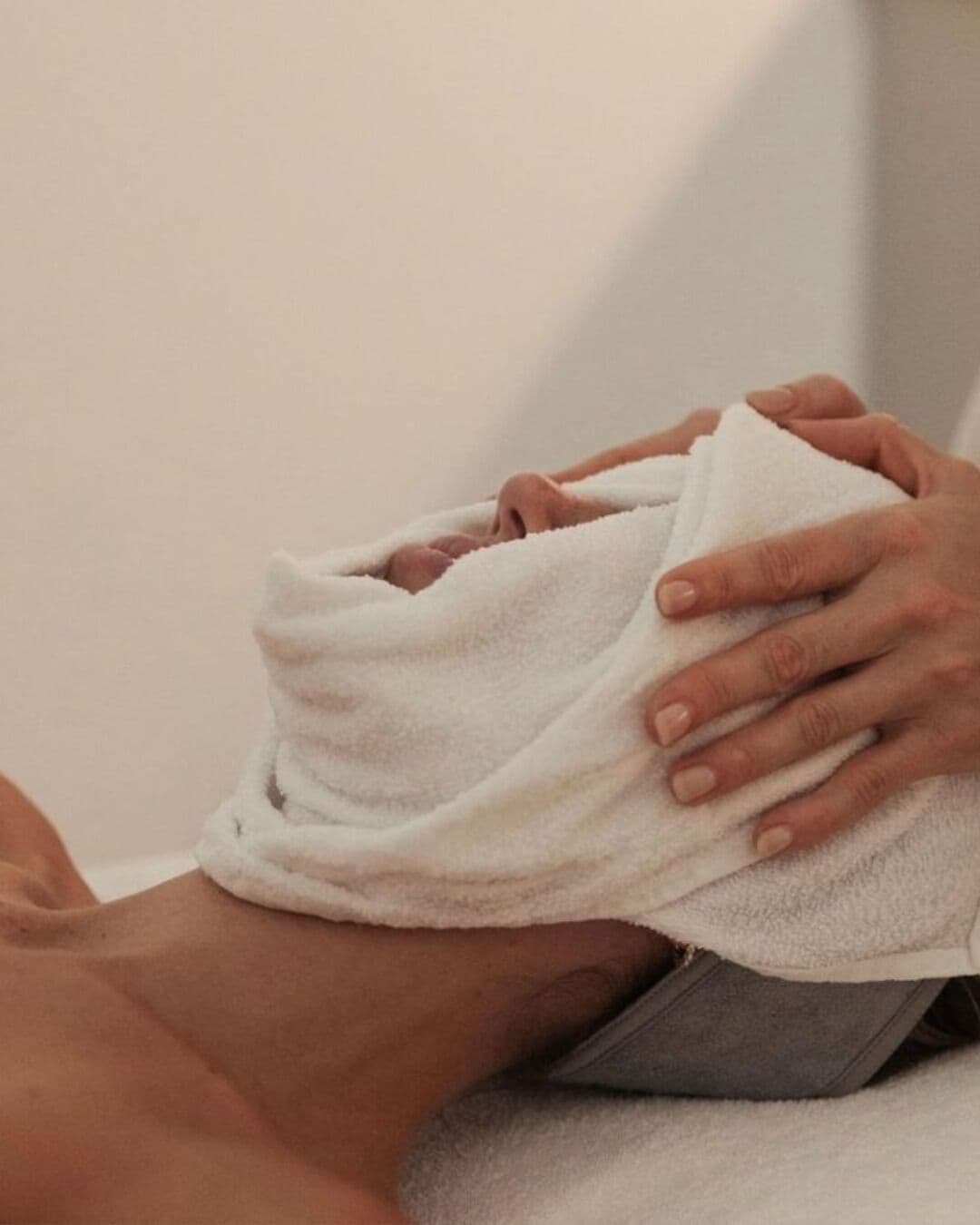 A person receiving a massage with a white towel.