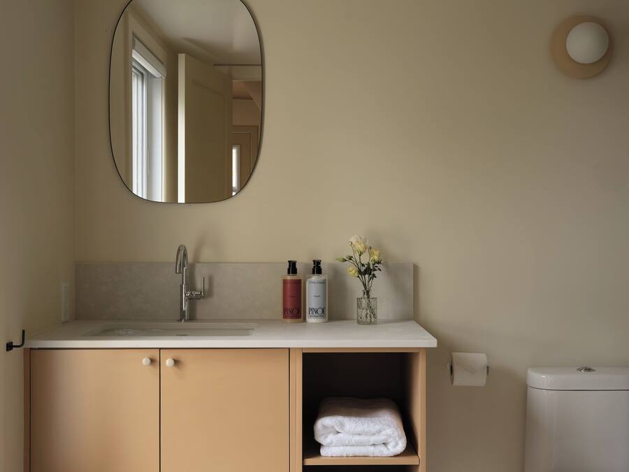 Une salle de bain équipée d’un lavabo, d’un miroir, d’articles de toilette et de toilettes.