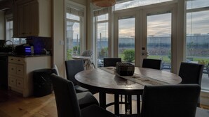 Una cocina con comedor, ventanas amplias y vista a un jardín.