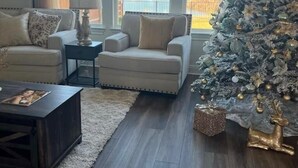 A living room with a large window, a white Christmas tree, and two armchairs. - New house. 20 minutes from ATX, 5 bedrooms (Manor)