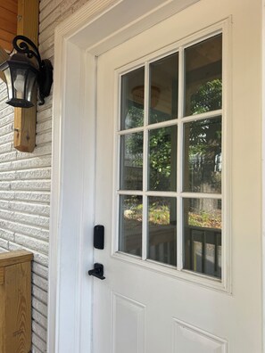 A white door with a glass panel, a black doorbell, and a wooden lantern on the wall. - 2-bedroom apartment in amazing Atlanta with AC close to downtown. (Atlanta)