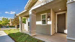 Una casa residencial con un porche cubierto, una puerta principal y un buzón.