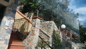 Una escalera de piedra con barandilla metálica y una lámpara.