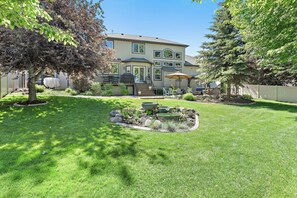 A two-story house with a front yard, a small garden, and a patio area. - Snuggle Down Inn: 1BR In-Law Basement Suite (Heber City)