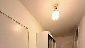 En hall med trägolv, vita väggar och en taklampa.