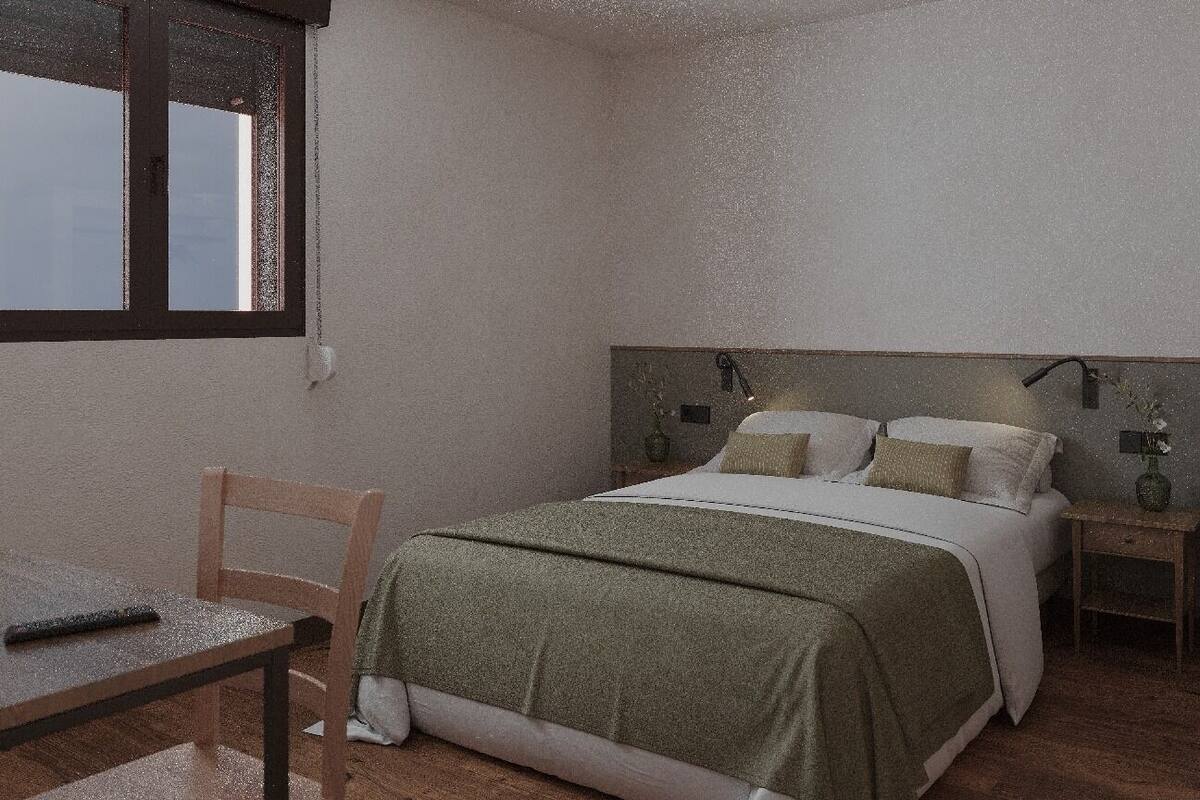 A bedroom with a bed, bedside tables, a chair, and a window.