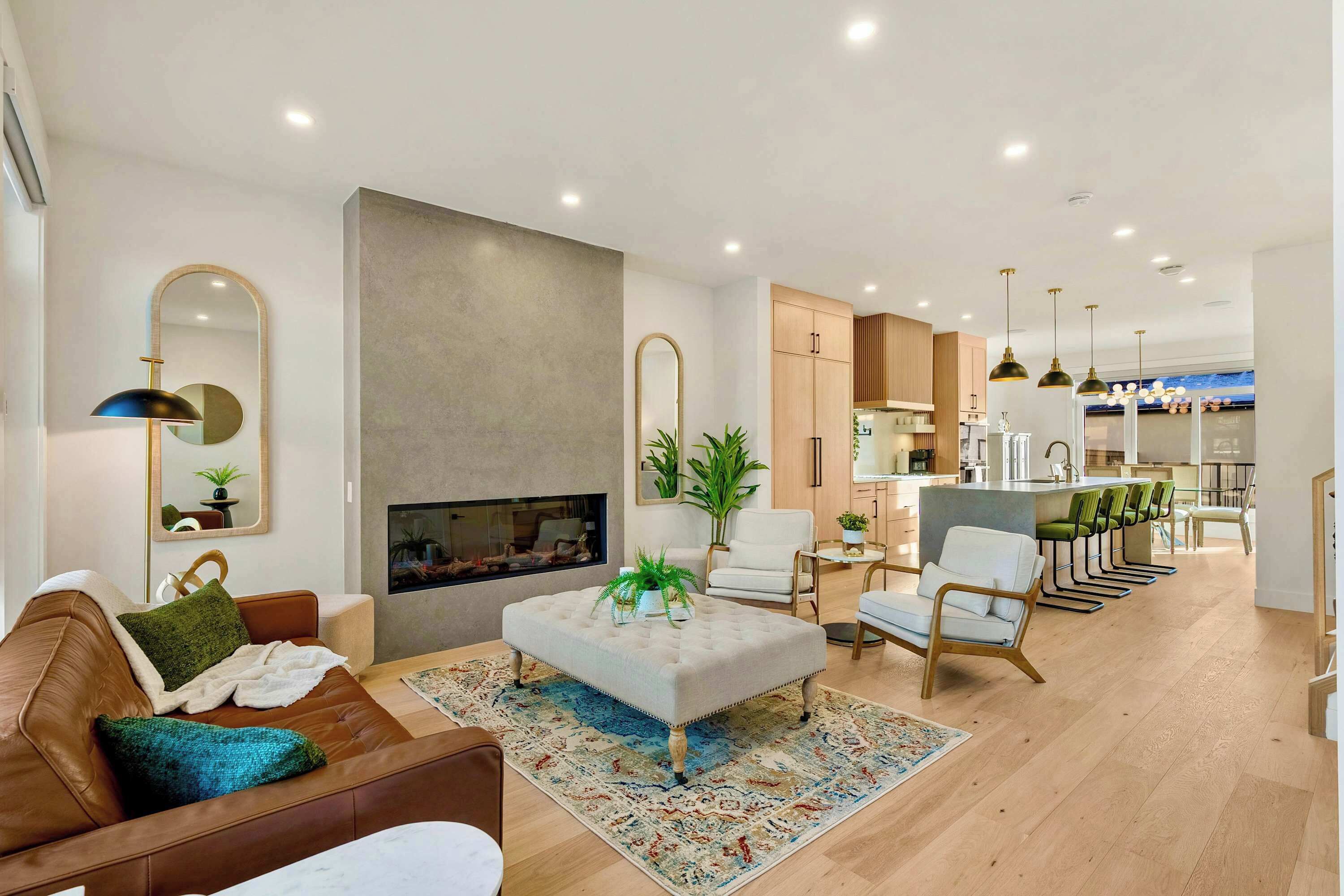 A modern living room with a fireplace, a sofa, a coffee table, and a dining area with chairs.