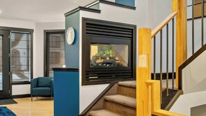Ein modernes Interieur mit einer Treppe, einer blauen Akzentwand und einer Sitzecke mit einem Sessel.