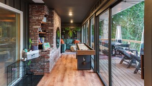 Un patio interior acogedor con chimenea de ladrillo, mesa de billar y una zona de estar confortable.