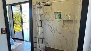 Un bagno moderno con doccia, pareti in marmo e pavimento in legno.