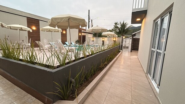 Ulkoterassi, jossa on aurinkovarjoja, tuoleja ja uima-allas.