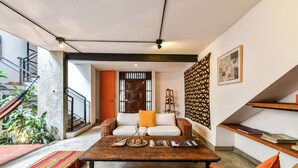 A modern living room with a sofa, coffee table, and a staircase leading to an upper level. - Casa Bolivar by Wynwood House (Medellín)