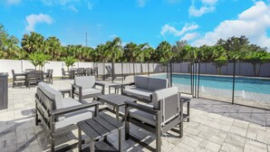 An outdoor pool area with lounge chairs and a pool. - Spacious 4BR Home w/ Heated Pool & Pickleball Court on 5-Acre Estate (Naples)