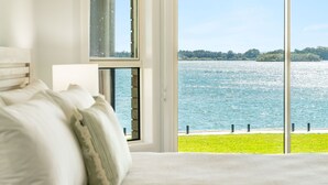 Une chambre avec une grande fenêtre donnant sur un lac.