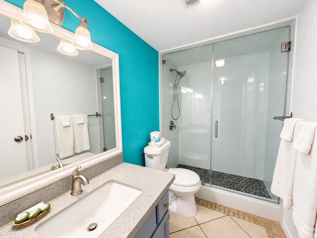 A bathroom with a sink, toilet, and shower.