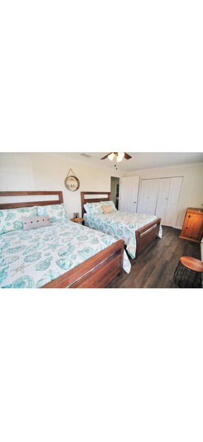 Ein Schlafzimmer mit zwei Holzbett, einem Deckenventilator und einem Kleiderschrank.