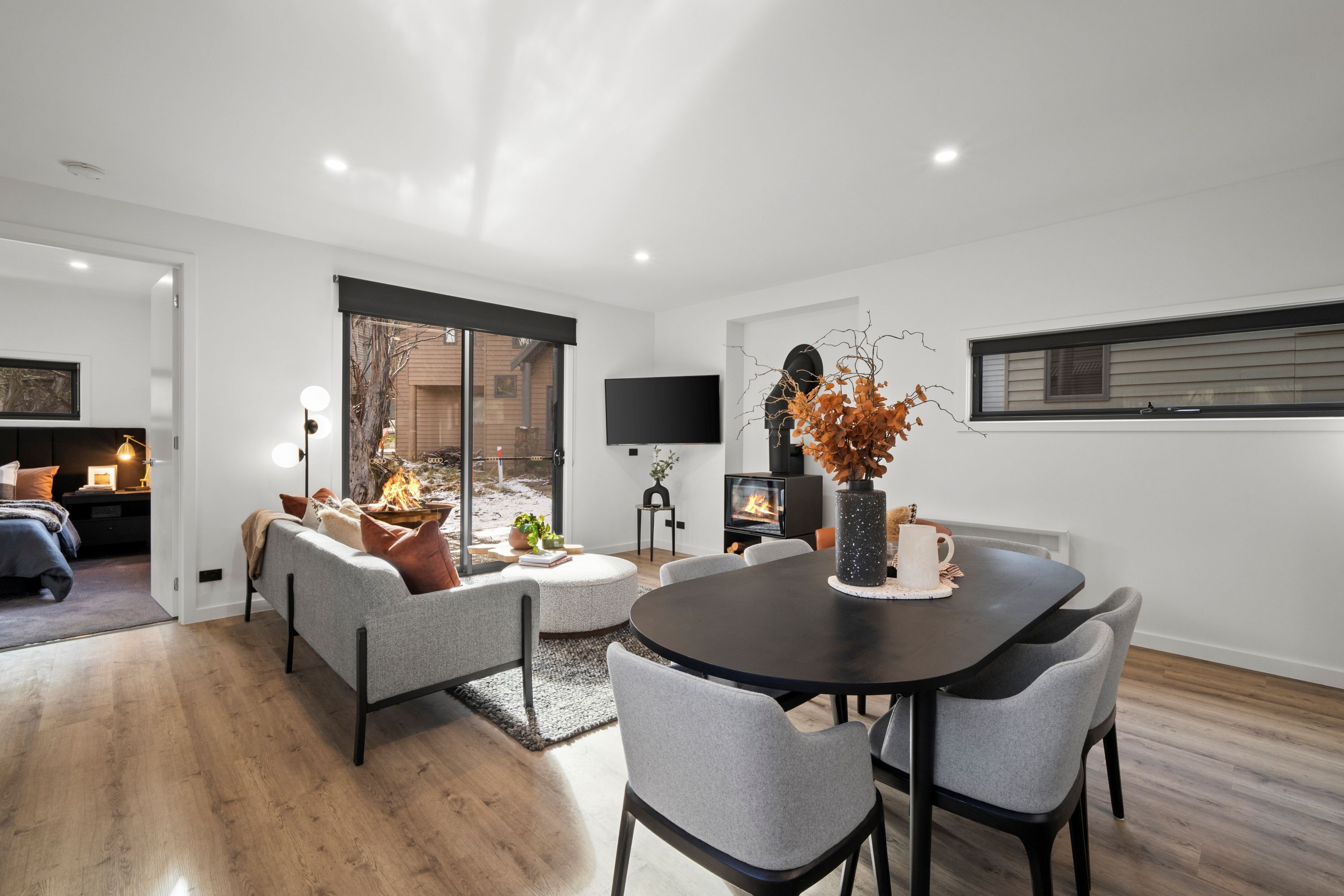 A modern living room with a fireplace, a dining table, and comfortable seating.