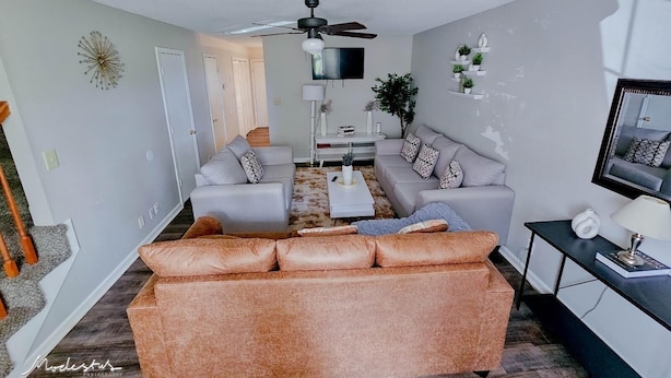 Ein modernes Wohnzimmer mit Sofa, Couchtisch und Deckenventilator.