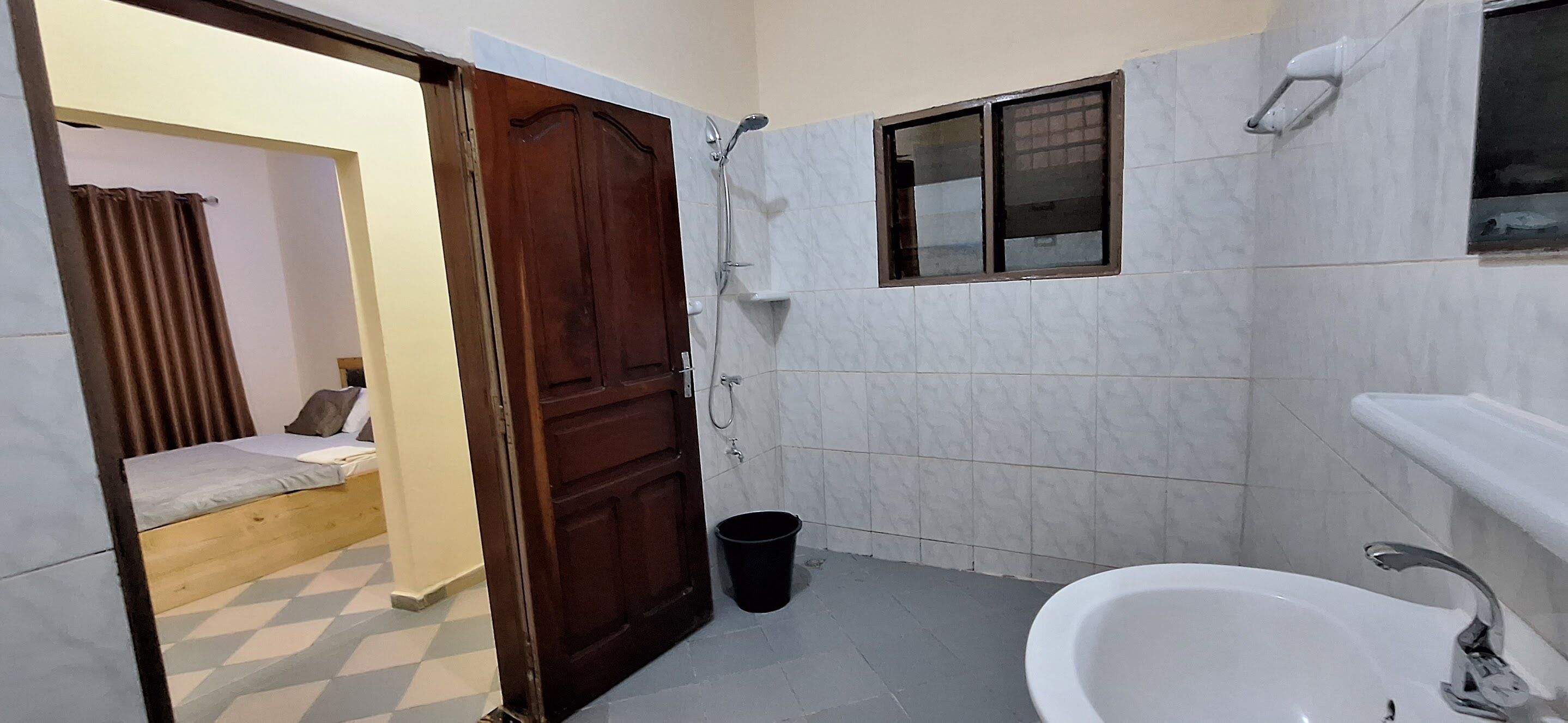 Ein Badezimmer mit Dusche, Waschbecken und Fenster.