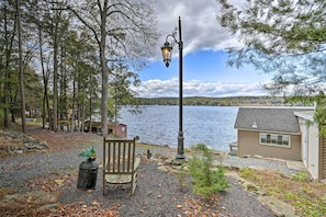 Une vue sur le lac, avec un banc, un lampadaire et un petit bâtiment.