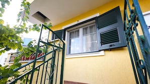 Un edificio amarillo con una ventana y una reja metálica.
