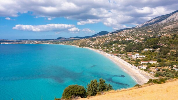 A coastal landscape with a beach, clear blue waters, and a town in the background. - a beautiful holiday home located in Katelios, Kefalonia (Katelios)