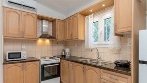 Une cuisine moderne avec des meubles en bois, un four à micro-ondes, une cuisinière et un évier.