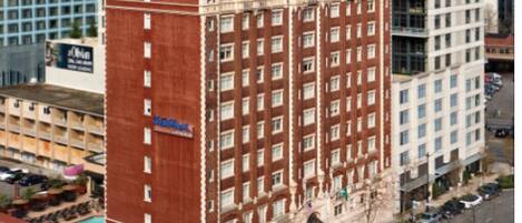 A multi-story hotel with a prominent red facade and a sign reading "Camlin."