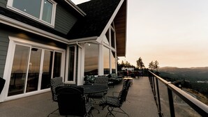 A modern house with a patio featuring outdoor furniture and a scenic view. - Blue Horizon Mountain Retreat B&B  (Shawnigan Lake)