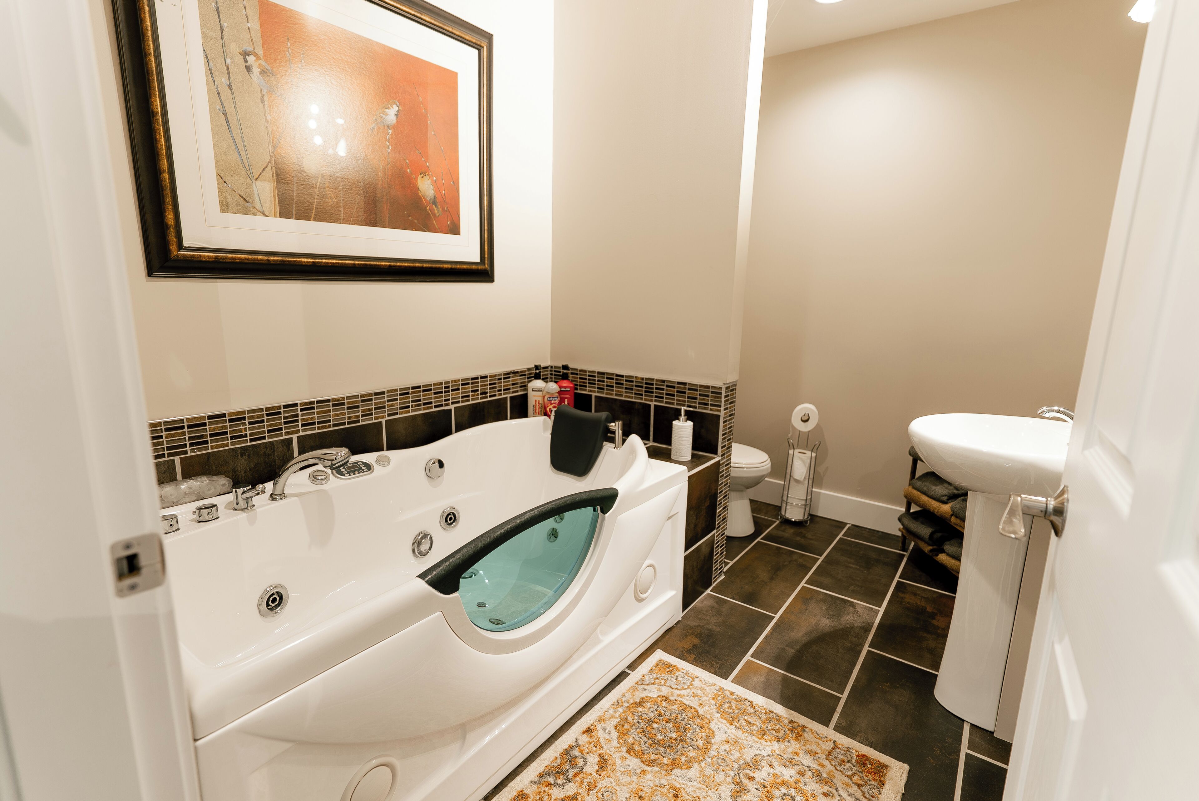 A modern bathroom with a freestanding bathtub, a toilet, and a sink.