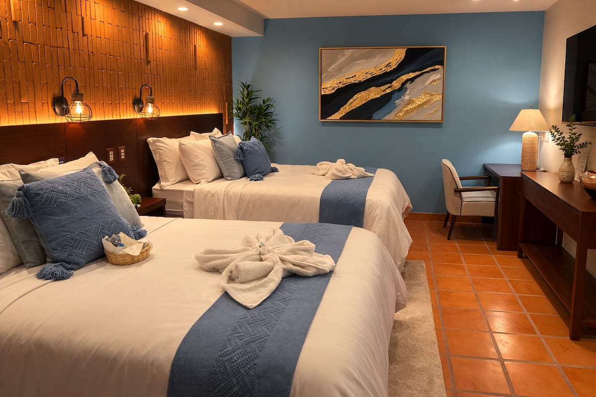 Una camera d'albergo con due letti, una scrivania e una sedia.