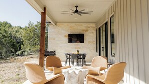 An outdoor patio with wicker chairs, a table, and a ceiling fan. - Luxury Ranch Near Palo Pinto Park with 10 Beds (Strawn)