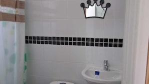 Uma casa de banho pequena com sanita, lavatório e cortina de chuveiro.