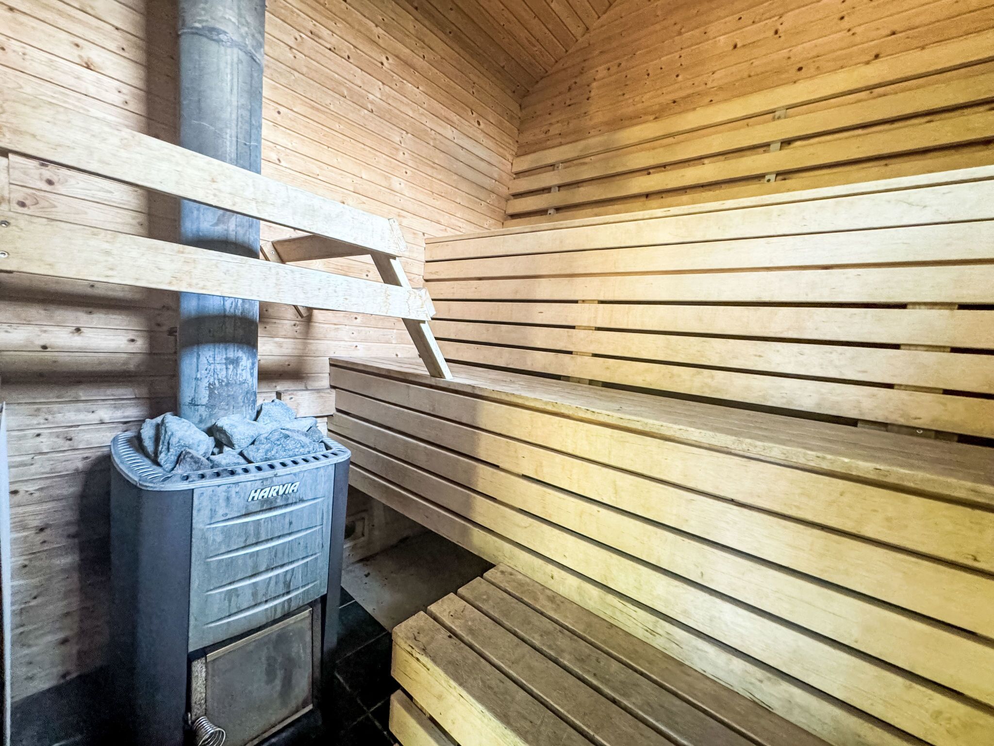 Een houten interieur met een ingebouwde houtkachel en een metalen rooster erboven.