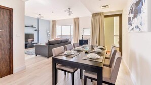 A modern dining area with a dark wooden table set for six, surrounded by six chairs. - Luxury 3BR JBR · Shams · Free 5* Beach Resorts Access! (Dubai)