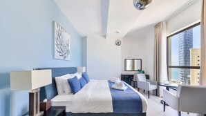 A modern hotel room with a neatly made bed, a desk, and a chair. - Luxury 3BR JBR · Shams · Free 5* Beach Resorts Access! (Dubai)